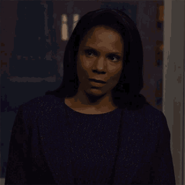 a woman in a purple dress looks surprised at something
