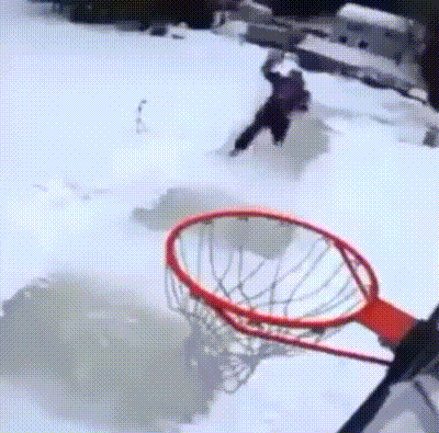 a person playing basketball in the snow with a basketball hoop