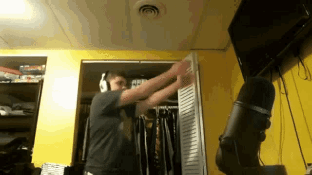 a man wearing headphones is standing in front of a microphone