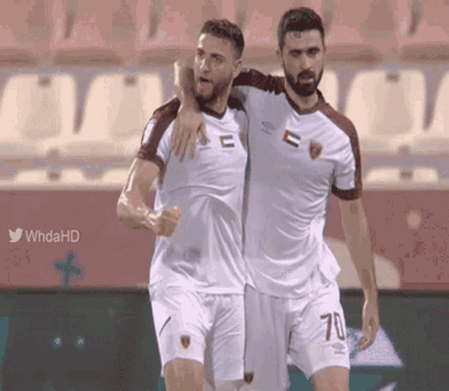 two soccer players with the number 70 on their shorts are hugging each other