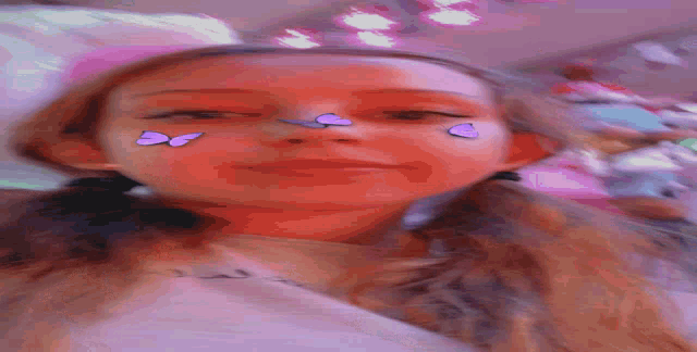a girl with purple butterflies painted on her face is laying down
