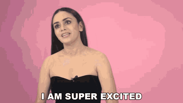 a woman says i am super excited while wearing a black strapless top