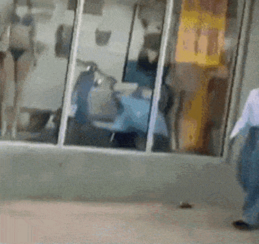 a woman in a bikini is standing in front of a window