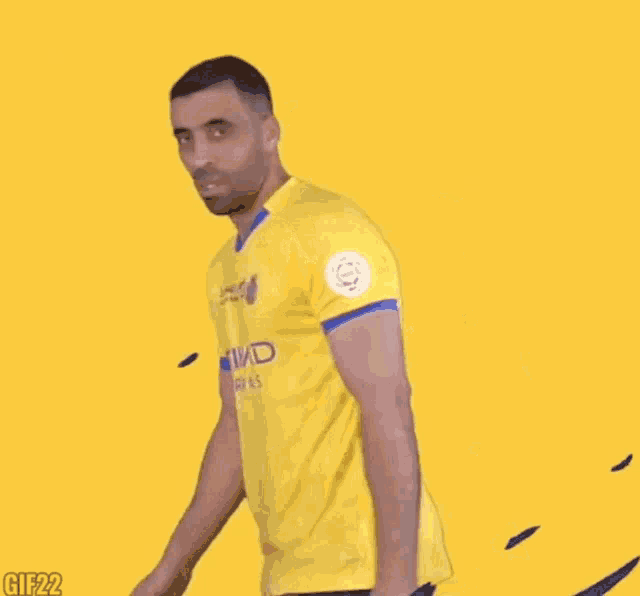 a man in a yellow etihad airways shirt is pointing at something