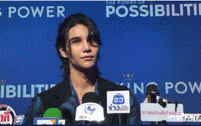 a man stands in front of microphones with a blue background that says king power