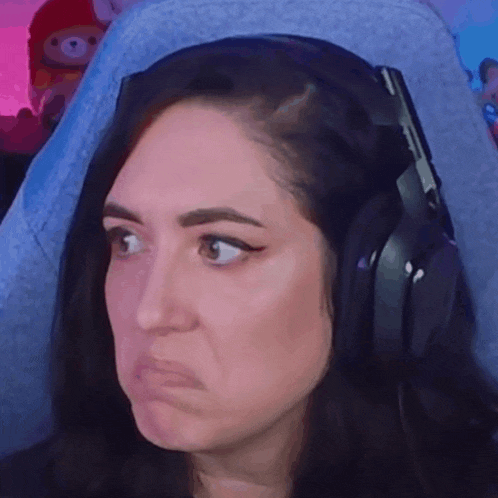 a woman wearing headphones is making a sad face .
