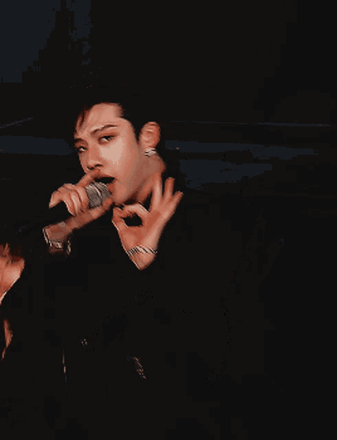 a man in a suit is holding a microphone in his hand