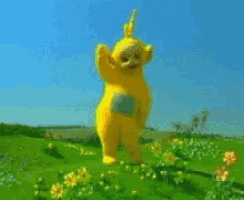 a yellow teddy bear is standing in a field of flowers