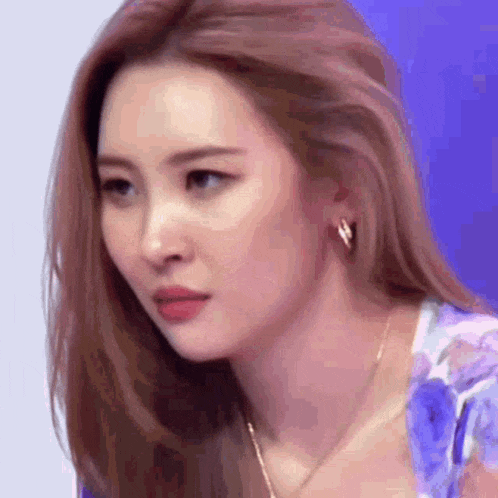 a close up of a woman wearing earrings and a necklace .