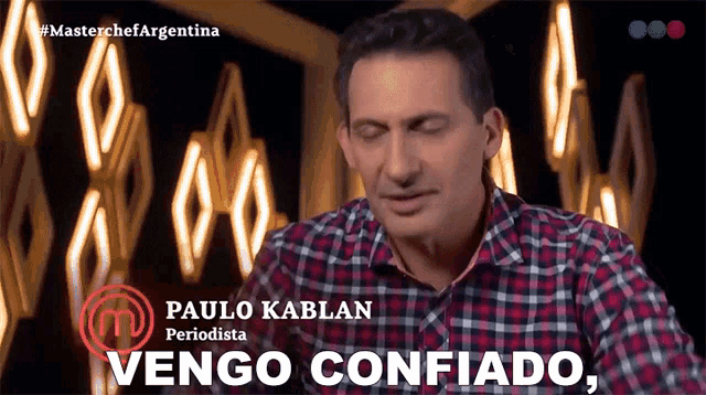 a man in a plaid shirt says " vengo confiado " in front of lights