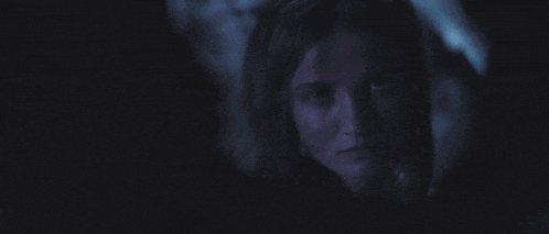 a close up of a person 's face in a dark room .
