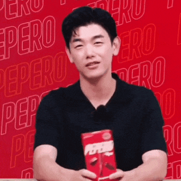 a man in a black shirt is holding a package of pepero .