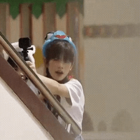a young boy is holding a camera while standing on a staircase .