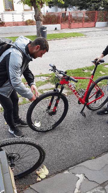 a man is putting a tire on a red bicycle that says altitude