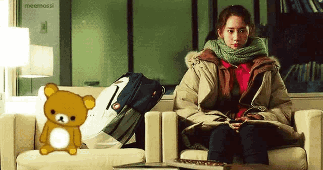 a woman is sitting on a couch with a teddy bear in front of her .