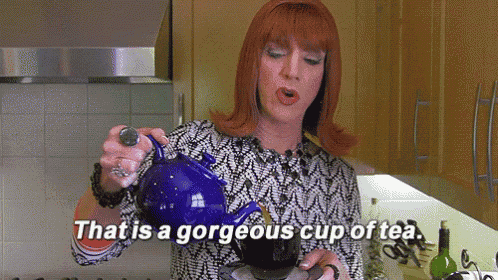 a woman is pouring a cup of tea from a blue teapot