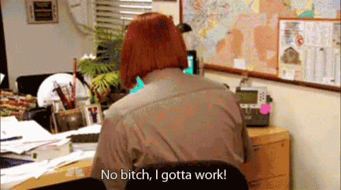 a woman with red hair is sitting at a desk and says no bitch i gotta work