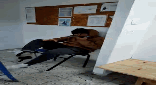 a man is laying on a chair in a room .