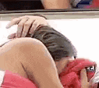 a close up of a person laying on a bed with their hands on their thighs .