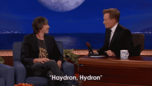 two men are sitting at a table with the words haydron hydron written on it