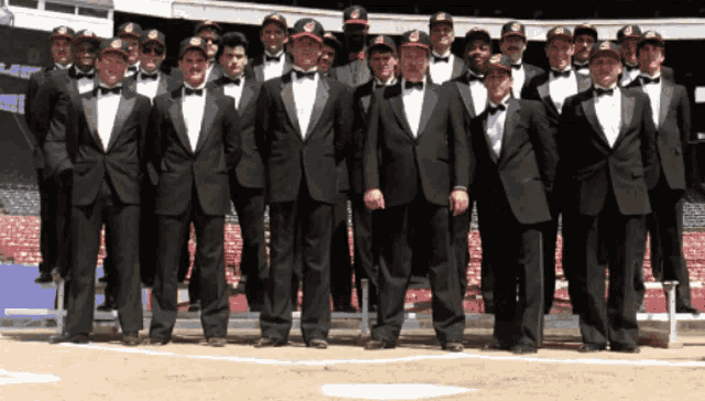 a group of men wearing tuxedos and bow ties pose for a photo