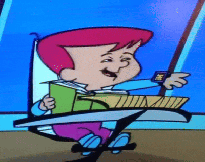 a cartoon character is sitting at a desk holding a book and a watch .