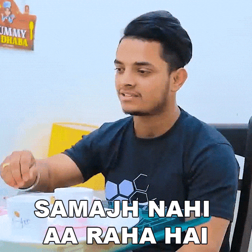 a man sitting at a table with the words samajh nahi aa raha hai in front of him