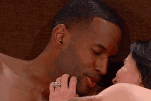 a woman with a ring on her finger touches a man 's neck