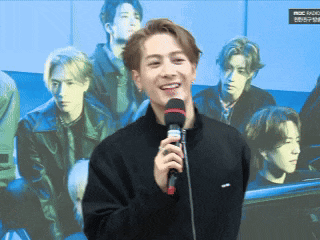 a man holding a microphone in front of a group of men