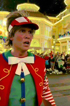a man in a clown costume is standing in front of a crowd of people