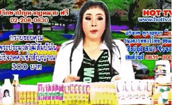 a woman stands in front of a sign that says ' hot tv '