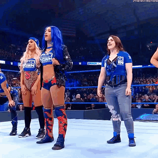 a woman with blue hair is wearing a shirt that says smack down on it