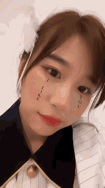 a close up of a woman 's face with the words " i love you " written on her face
