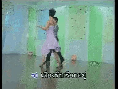 a woman in a purple dress is dancing with a man in a grey suit