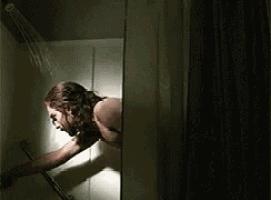 a man is taking a shower in a dark room