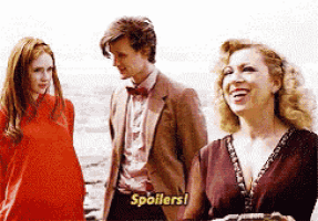 a man in a suit and bow tie is standing next to two women and says spoilers