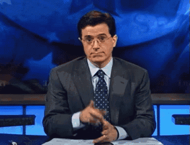 a man in a suit and tie is giving a ok sign