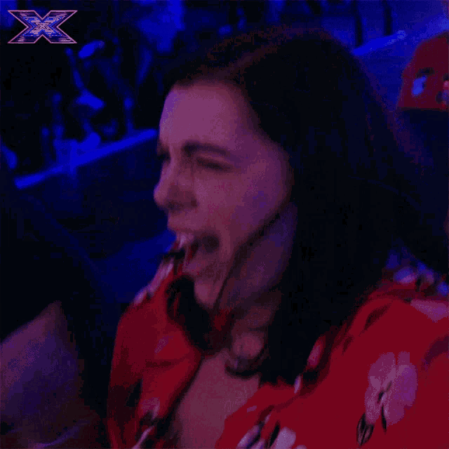 a woman in a red shirt is screaming with an x on the bottom