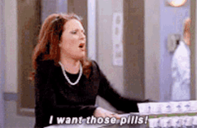 a woman is sitting at a counter and talking about pills .