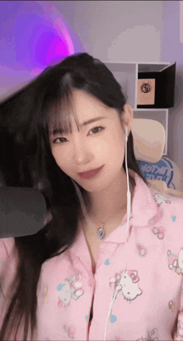 a girl wearing a pink hello kitty pajama top looks at the camera