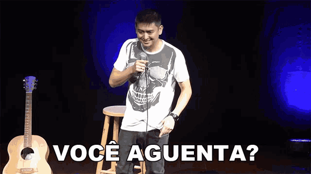 a man singing into a microphone next to a guitar that says voce aguenta on it