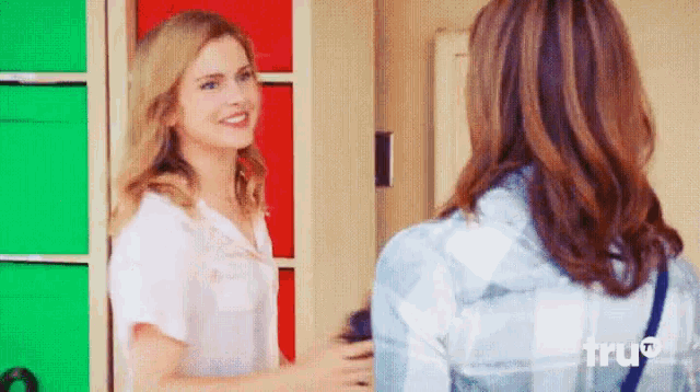 two women are standing next to each other and one of them is wearing a plaid shirt that says true