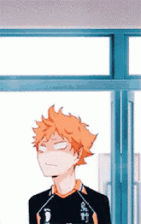 a man with orange hair is standing in front of a window with his eyes closed .