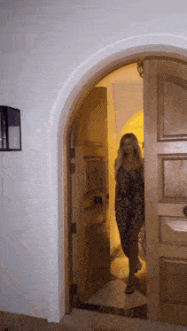 a woman in a leopard print dress stands in a doorway