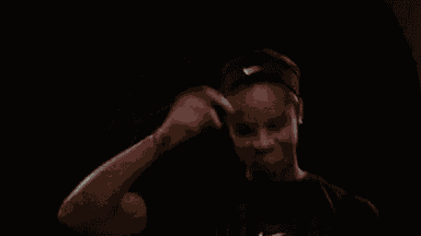 a woman wearing a purdue t-shirt is pointing at the camera .