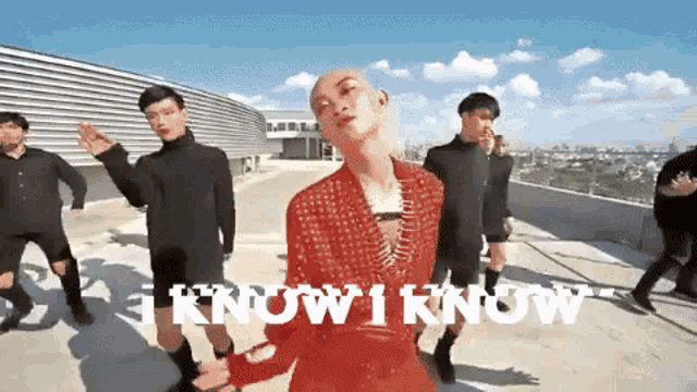 a group of men are dancing on a rooftop with the words " i know i know " written on the bottom