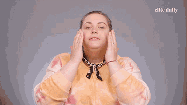a woman covering her eyes with her hands with the elite daily logo in the corner