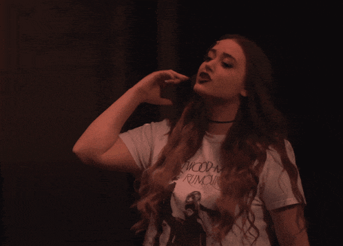 a woman wearing a white t-shirt that says " woody mc rumble "