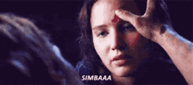 a woman with blood on her forehead is being touched by a man 's hand and says simbaa .