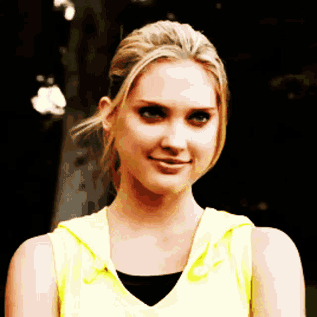 a woman in a yellow tank top with a hood